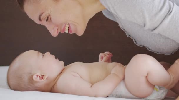 Primer plano. Madre besa suavemente al bebé disfrutando de una madre cariñosa cuidando juguetonamente al niño pequeño en casa compartiendo la conexión con su hijo recién nacido. Cuidado de niños saludable. — Vídeos de Stock