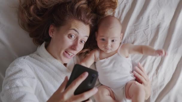 Moeder en haar dochtertje maken selfie of videogesprek naar vader in bed, Familie, Thuisveiligheid, ouderschap, technologie concept. — Stockvideo