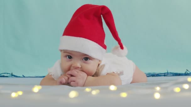 God Jul och Gott Nytt År, Barndom, Semester koncept närbild. 3 månader gammal nyfödd baby i Santa Claus hatt på magen kryper. — Stockvideo