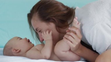 Genç annenin yakın plan çekimi, yeni doğmuş bebeğiyle bir sabah kreşte oynayacak. Çocuk, bebek, ebeveynlik, çocukluk, hayat, annelik, annelik kavramı.