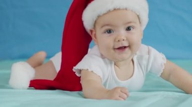 Noel Baba şapkası takan sevimli bebek kızın portresi. Noel kutlaması kavramı.