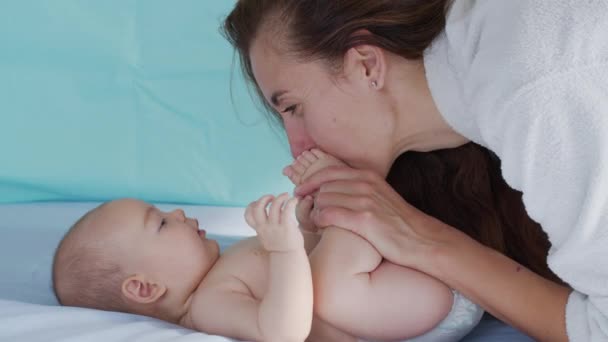 Primer plano de la joven madre está jugando con su bebé recién nacido en un vivero en una mañana. Concepto de hijos, bebé, paternidad, infancia, vida, maternidad, maternidad. — Vídeos de Stock