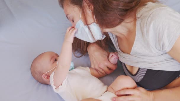 Mother putting on Protective mask to her son to protect from Corona virus or Covid-19 virus outbreak. The baby in face protective mask, — Stock Video