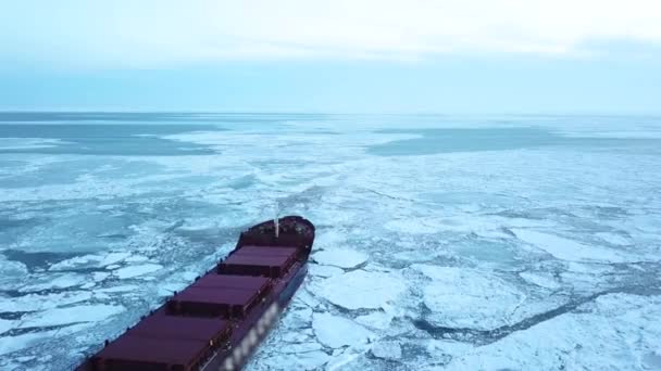 Aerial epischen roten Schiff im Winter segelt durch gefrorene See macht seinen Weg. Grafisches Muster der Eisschollen. Spezialschiff für Eisbrecheroperationen machte eine Expedition Nordpol, Arktis. — Stockvideo