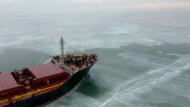 Aerial epic red ship in winter sails through frozen sea makes its way. Ice floe graphic pattern. Specialized vessel for icebreaking operations made an expedition North pole, Arctic. — Stock Video