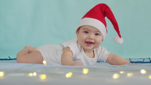 Feliz Natal e feliz ano novo, infância, feriados conceito close-up. 3 meses de idade bebê recém-nascido em chapéu de Papai Noel em sua barriga rasteja. — Vídeo de Stock