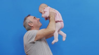 Kafkasyalı Yaşlı Adam ve Bebek Kız Evcil Konforda Komik Oyun ve Kahkaha Büyükbabanın buruşuk derisi ya da doğal ışıklandırmadaki gri saçlı baba..