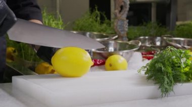 Lemon 'u kesen bir bıçağı tutan el dilimlenmiş limonla dolu..