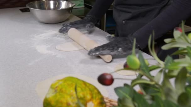 Closeup shot of hands in black gloves bakery chef applying flour on dough, isolated background 4k footage. — Stock Video