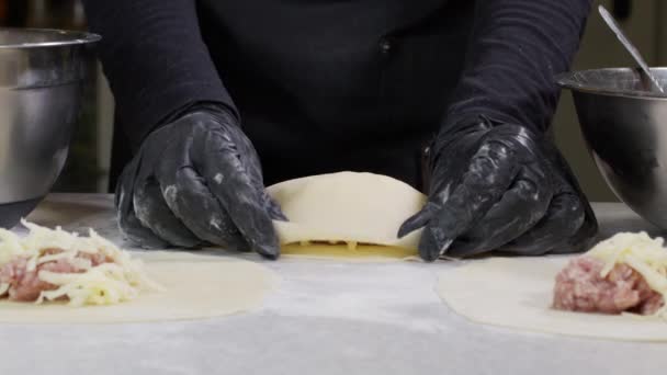 검은 장갑 빵집 요리사가 밀가루를 반죽에 바르는 모습을 클로즈업 된 손으로 찍은 4k 필름이 격리되어 있다.. — 비디오