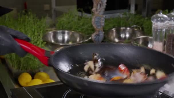 Chef bereidt garnalen met vuur in een koekenpan in de keuken van het restaurant. Langzame beweging. Zeevruchten schotel gekookt in brandende vlam. Flambe stijl. Kookingrediënten voor soep. — Stockvideo