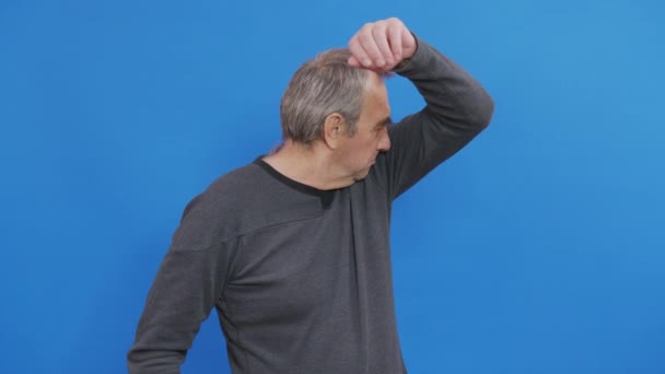 Gammal man som sniffar på armhålan, något stinker väldigt illa. Dålig lukt koncept. — Stockvideo