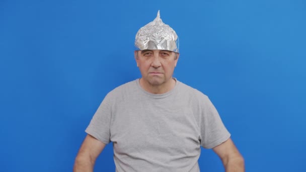 Bang man in een aluminiumhoed zwaaide van de 5G golven.5G toren stralingsbescherming. Irrationele angst voor een niet bestaand probleem. Beschermende folie helm naar de hersenen tegen aliens. — Stockvideo