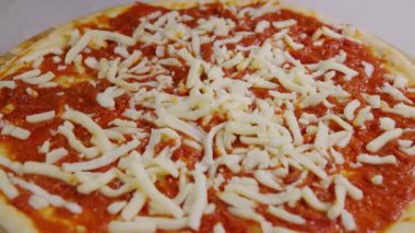 İtalyan pizzası pişiren bir aşçının yakın görüntüsü. Masada pizza yapma süreci. Mutfak masasında taze hamur. İzolasyon döneminde evde yemek pişirmek, 2020 salgını. Evde kal konsepti.