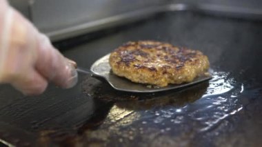 Peynirli burger için biftek ve domuz köftesi. Mutfakta kızartılmış et. Etrafta yağ damlaları ve duman var..