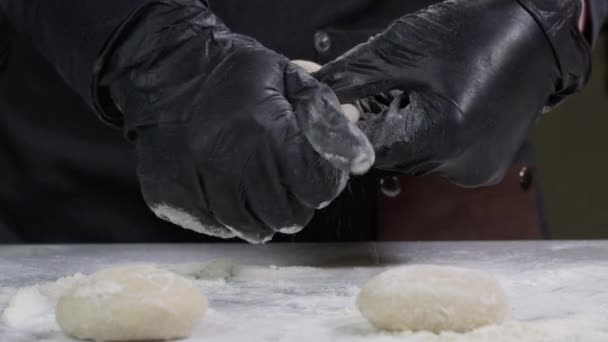 Detailní záběr rukou v černých rukavicích pekařství kuchař nanášení mouky na těsto, izolované pozadí 4k záběry. Vaření doma během období izolace, pandemie2020. Zůstaň doma.. — Stock video