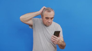 Mutlu yaşlı adam elinde akıllı bir telefonla internetten cep telefonuyla arıyor..