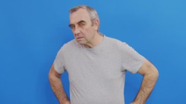 Şüphe kavramı. Kameraya bakan ciddi bir olgun adam, mavi stüdyo geçmişi..