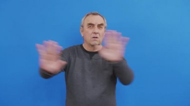 Duygusal tedirgin bir adam el ele tutuşuyor ve hayır diyor. Kafasını sallıyor ve reddediyor. Mavi stüdyo geçmişi var..