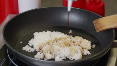 Şef, lokanta mutfağında tavada karides pişiriyor. Ağır çekim. Yanan ateşte pişirilmiş deniz ürünleri yemeği. İzolasyon döneminde evde yemek pişirmek, 2020 salgını. Evde kal konsepti.