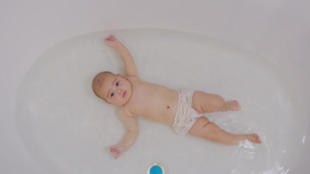 Feliz banho de bebé. Criança alegre de cinco meses de idade em água. — Vídeo de Stock