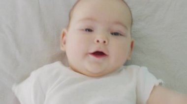 Güzel, küçük bir bebek kameraya gülümsüyor, yumuşak bir odak arkaplanı var..