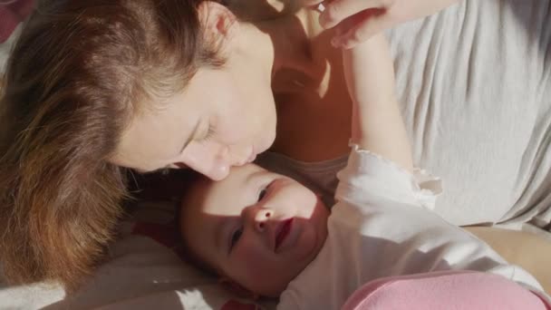 Nahaufnahme Mutter sanft küsst Baby genießen liebevolle Mutter spielerisch Pflege Kleinkind zu Hause teilen Verbindung mit ihrem Neugeborenen, gesunde Kinderbetreuung. — Stockvideo