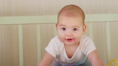 Mutlu bebek beşiğinde yatar ve gülümser.