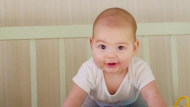 Το χαρούμενο μωρό κείτεται στην κούνια και χαμογελάει. — Αρχείο Βίντεο