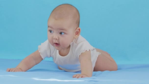 Batole holčička leží na břiše a usmívá se. — Stock video