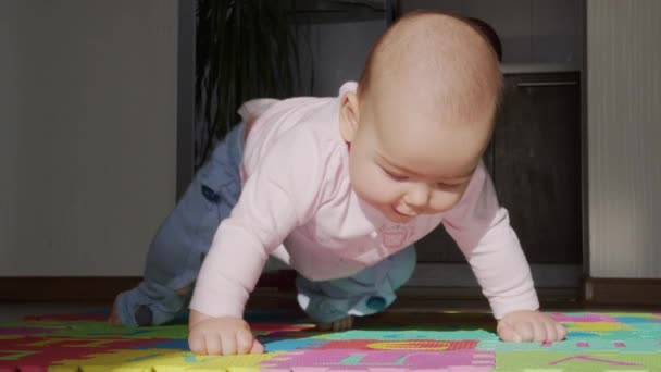 Gelukkige baby kruipt in de kamer. Baby baby speelt met familie in het huis en leert hoe te kruipen. — Stockvideo