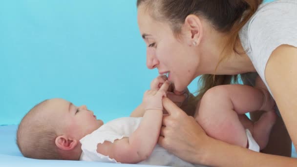 Közelkép anya gyengéden csók baba élvezi szerető anya játékosan gondoskodó kisgyermek otthon megosztás kapcsolat vele újszülött gyermek, egészséges gyermekgondozás. — Stock videók