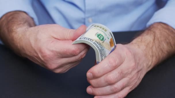 Um homem segurando um maço de dólares em sua mão. — Vídeo de Stock