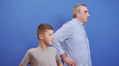 Dedem ve torunum mavi arka planda ısınıyor. Sağlıklı yaşam tarzı kavramı.