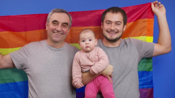 Autentyczne strzał z szczęśliwy homoseksualny mężczyzna gej rodzina z adoptowany maluch dziecko dziewczyna to uśmiech w kamera. — Wideo stockowe