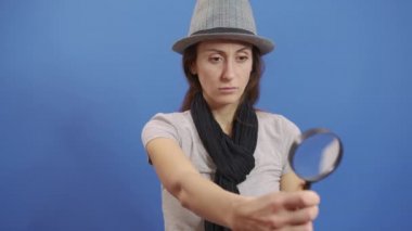 Komik kız kameraya büyüteç fırlatıyor. Modayı takip eden kızıl saçlı kadın eğleniyor. Renkli Portre. Güzel kız. Komik çerçeve. Muhteşem Gözler. Yakın çekim..