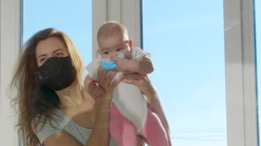 Koruyucu maskeli kadın, katı karantina döneminde onları ayıran cam pencere vasıtasıyla iletişim kuruyor..
