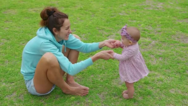 Heureuse petite fille jouant avec sa mère en plein air dans le parc adorable style de vie de bébé. — Video