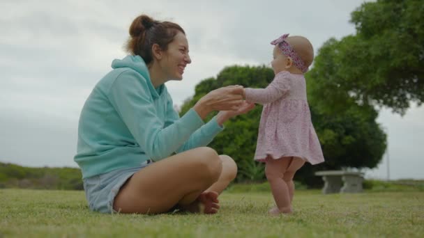 Heureuse petite fille jouant avec sa mère en plein air dans le parc adorable style de vie de bébé. — Video