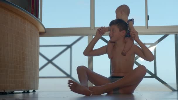 Amusez-vous bien. Garçon jouant avec une petite fille. Mon frère aîné s'occupe du bébé. Beaux enfants jouant ensemble à la maison. — Video