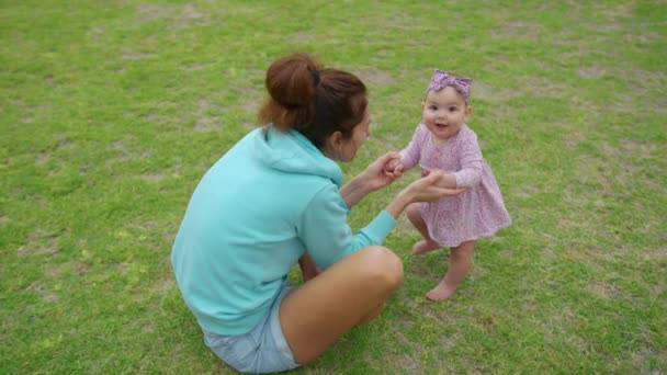 Heureuse petite fille jouant avec sa mère en plein air dans le parc adorable style de vie de bébé. — Video