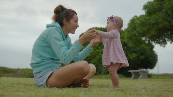 Gelukkig klein baby meisje spelen samen met haar moeder outdoor in het park schattig baby levensstijl. — Stockvideo