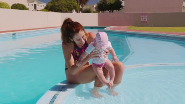 En mamma och ett barn i en utomhuspool. Mor kysser småbarn vid poolen. Mamma omfamnar hålla och ta hand om spädbarn. — Stockvideo