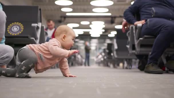Little baby girl crawling in the airport lounge. — Stock Video