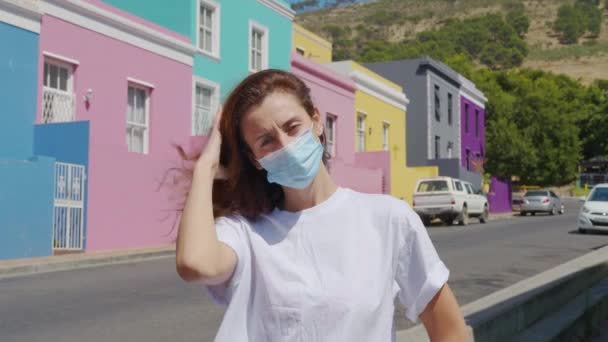 Vrouw gemaskeerd tijdens quarantaine in de straten van kleurrijke gebouwen buurt Bo-Kaap Kaapstad Zuid-Afrika. — Stockvideo
