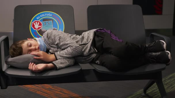 Barnet sover i flygplatsloungen i väntan på sitt flyg. — Stockvideo