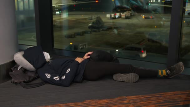 A nő a reptéri váróban alszik a földön, miközben a gépére vár.. — Stock videók