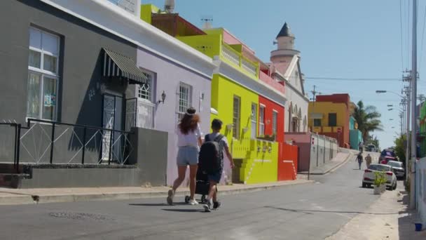 Mulher andando com o filho e carrinho de bebê nas ruas de edifícios coloridos bairro Bo-Kaap Cidade do Cabo África do Sul. — Vídeo de Stock