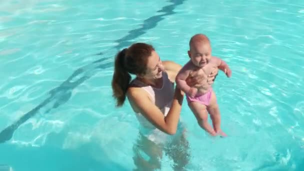 Mor och barn tillsammans vid poolen. Mamma stödja spädbarn barn vid poolen vatten. — Stockvideo