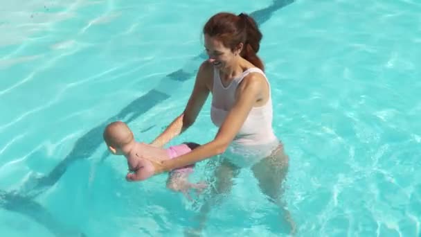 Mor och barn tillsammans vid poolen. Mamma stödja spädbarn barn vid poolen vatten. — Stockvideo